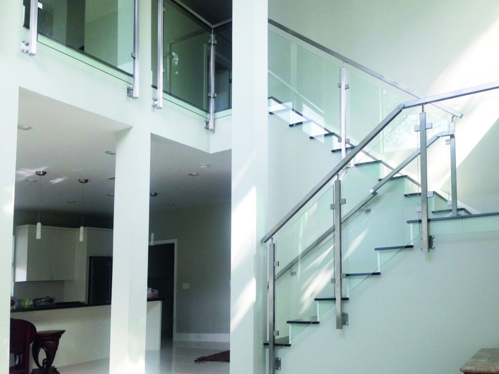 piso moderno interior con escalera y barandilla de cristal